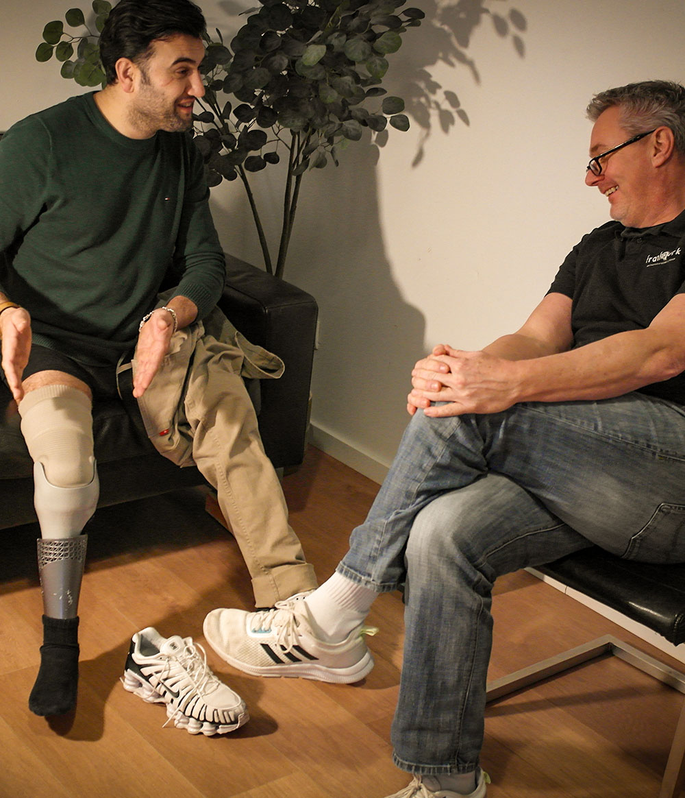 Orthopädietechniker von Frank Purk im persönlichen Erstgespräch mit einem Patienten mit Beinprothese in entspannter Atmosphäre in Hamburg